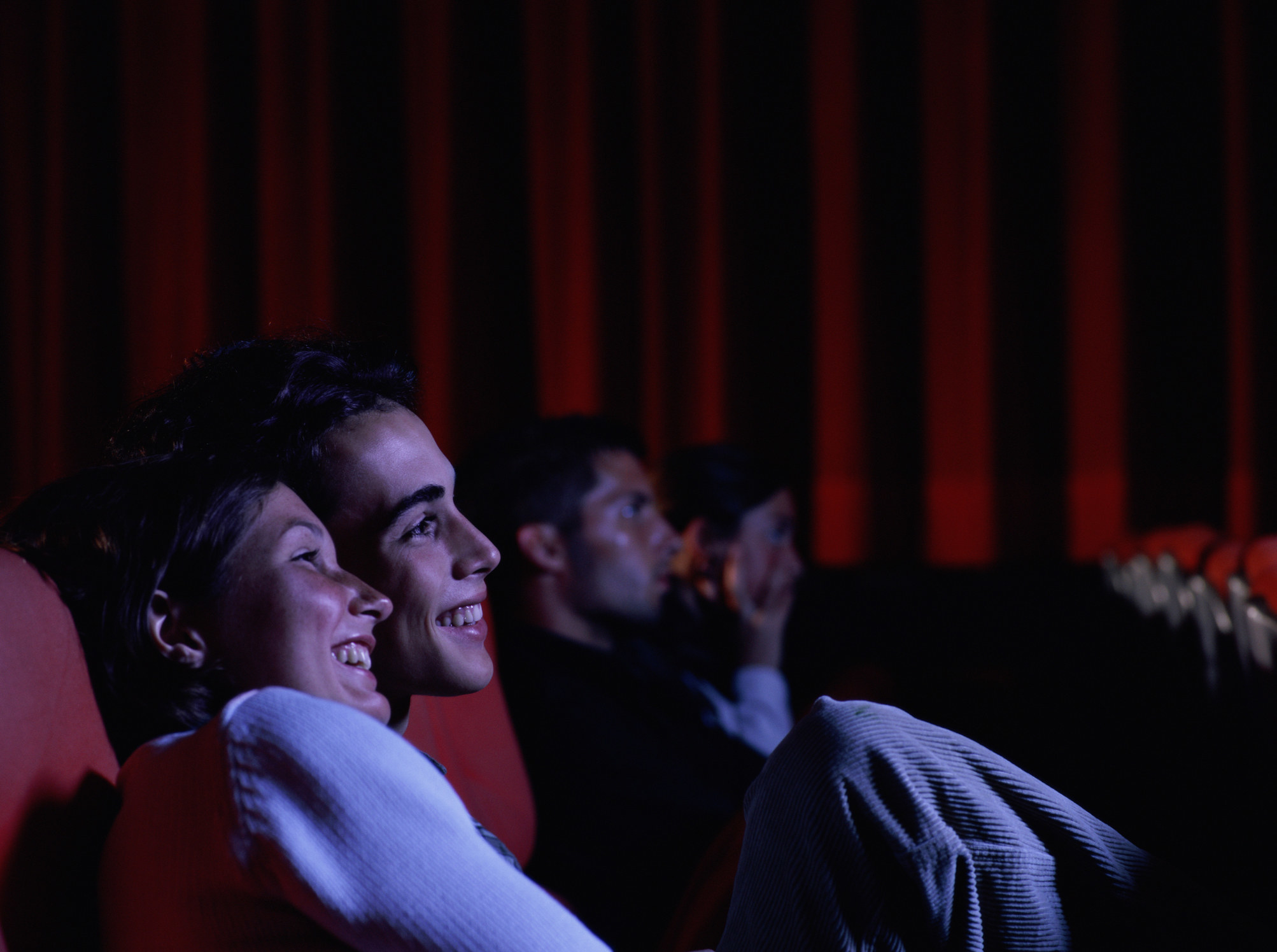 A couple watching a movie in a theater together