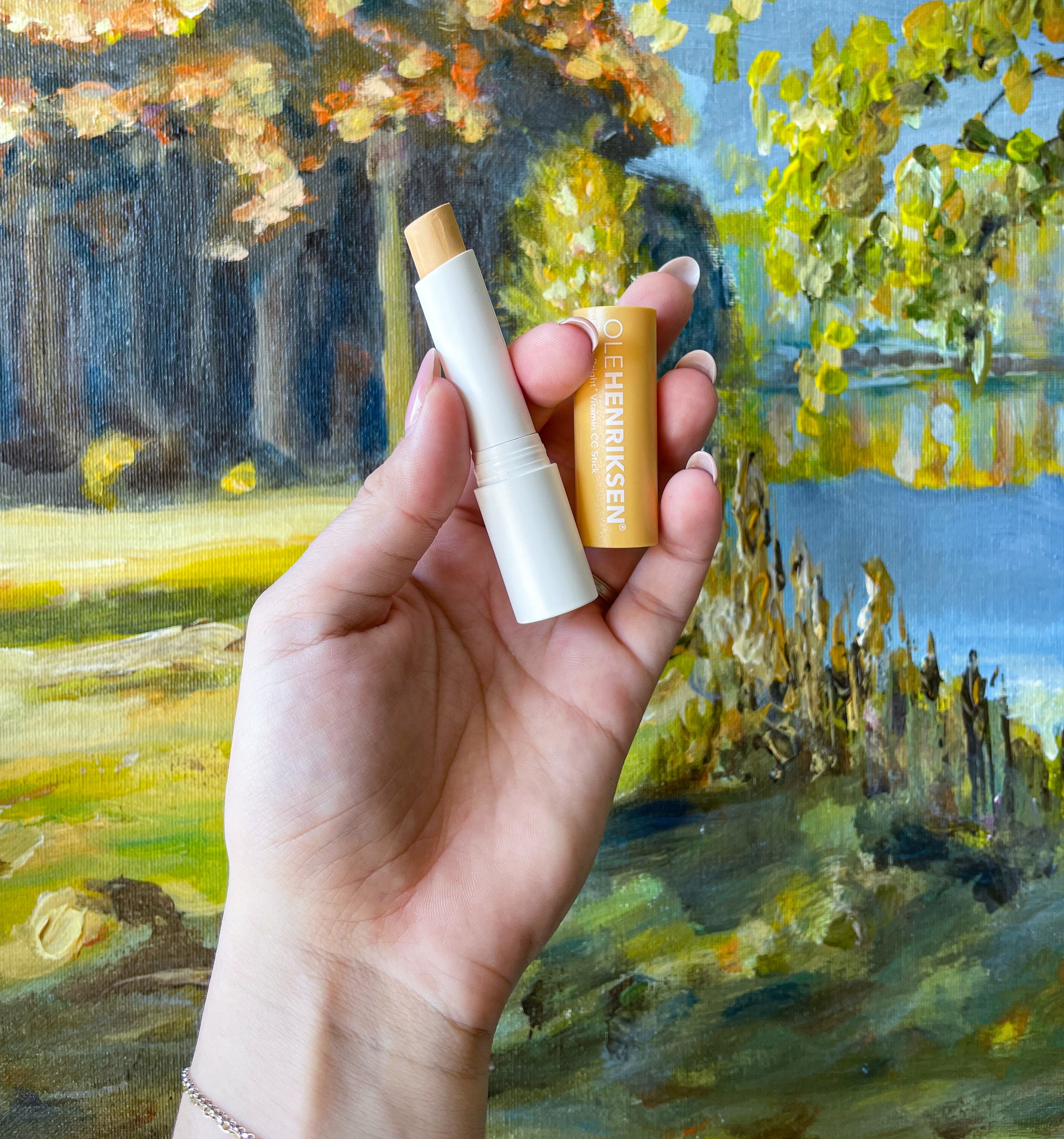 victoria holding a tube of the cc sticks against a painting