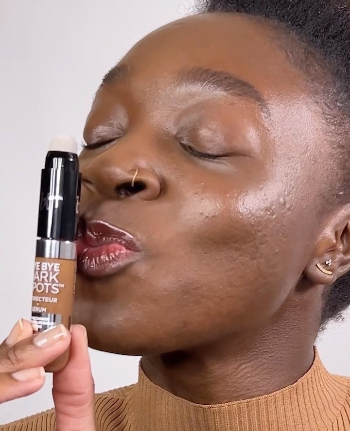 someone kissing a tube of the concealer serum