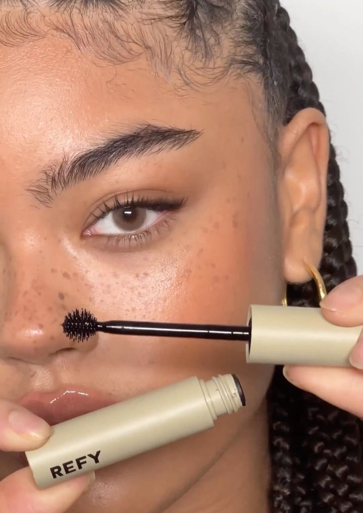 a person holding up a tube of the brow tint before applying it to their eyebrows