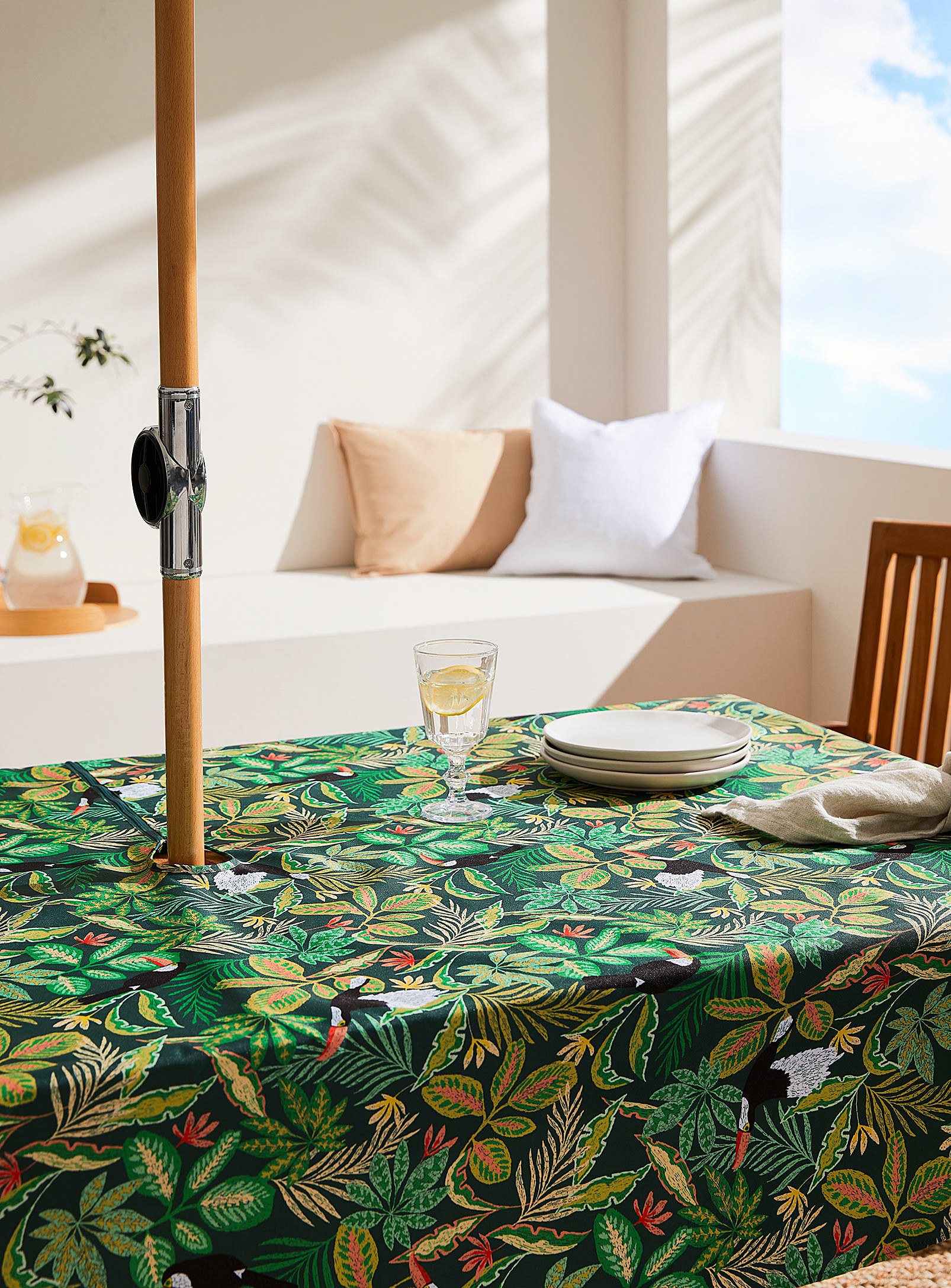 the leaf print table cloth on a picnic table with an umbrella in the middle