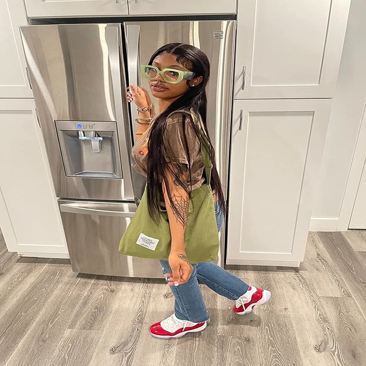 Reviewer wearing the dark olive green bag