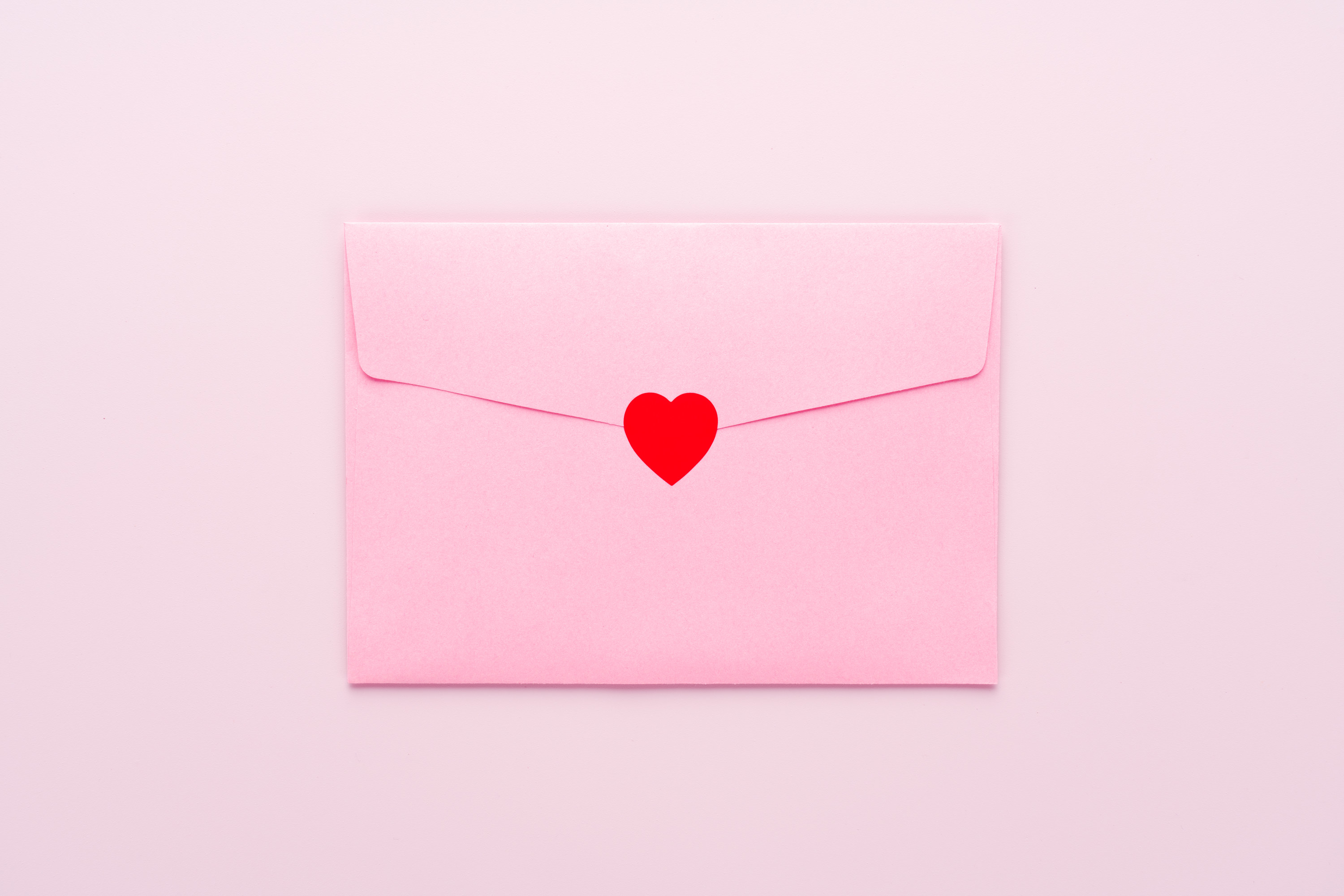 Pink envelope sealed with a red heart sticker