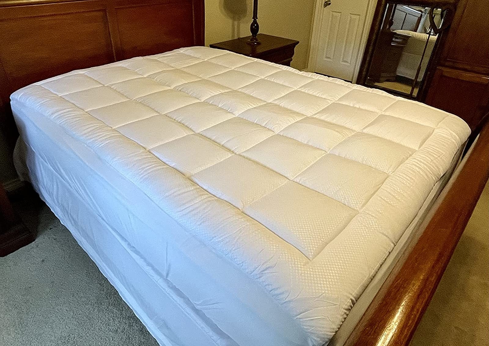 A reviewer&#x27;s photo of the mattress topper on the bed