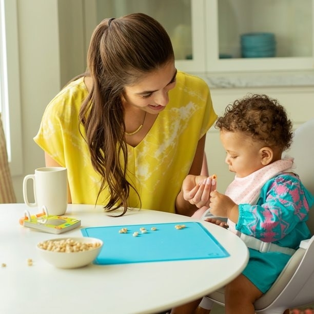 Parent and toddler use a placemat