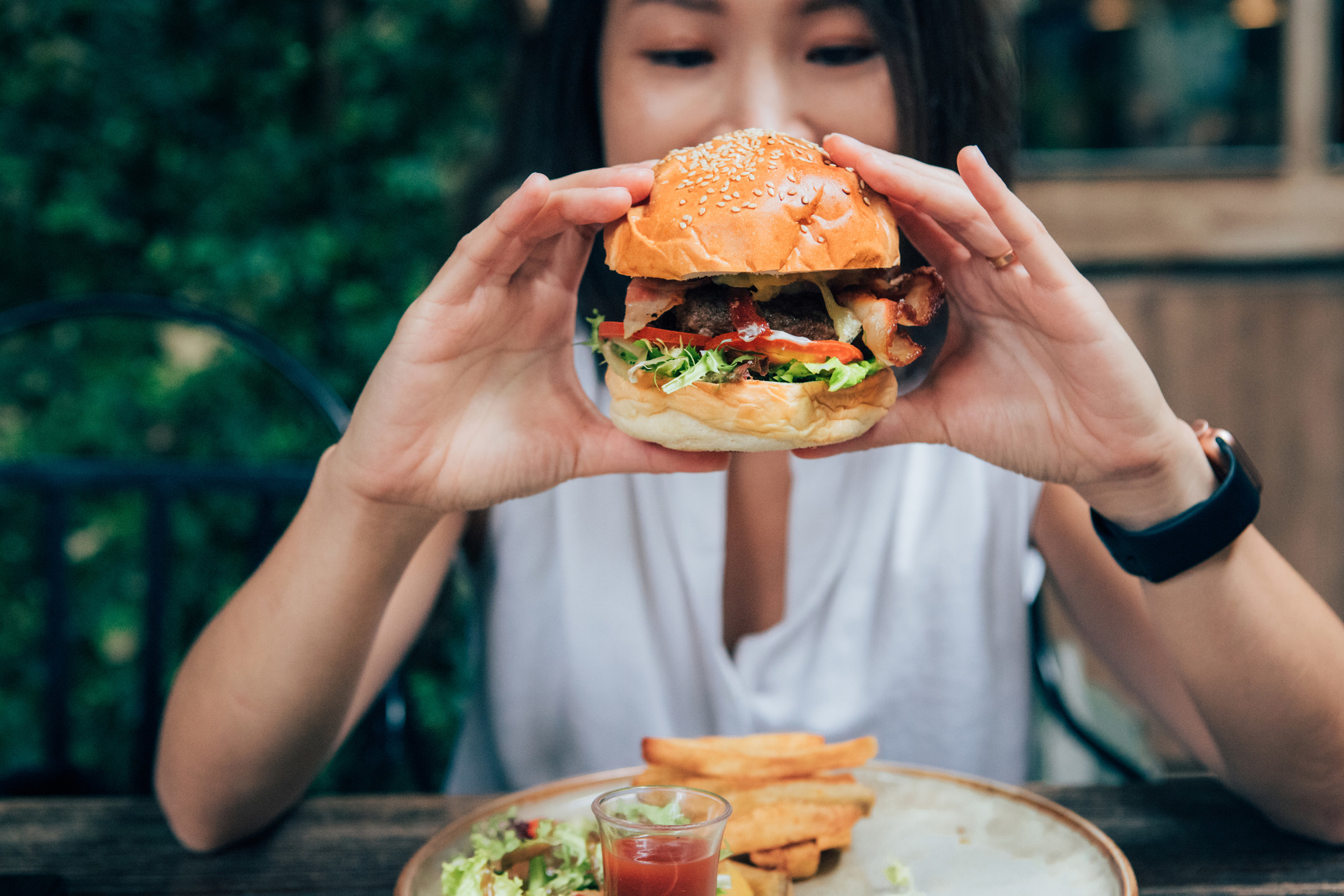 A woman holding up a burger