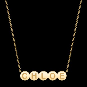 a dainty gold necklace with gold bubbles as a nameplate that say
