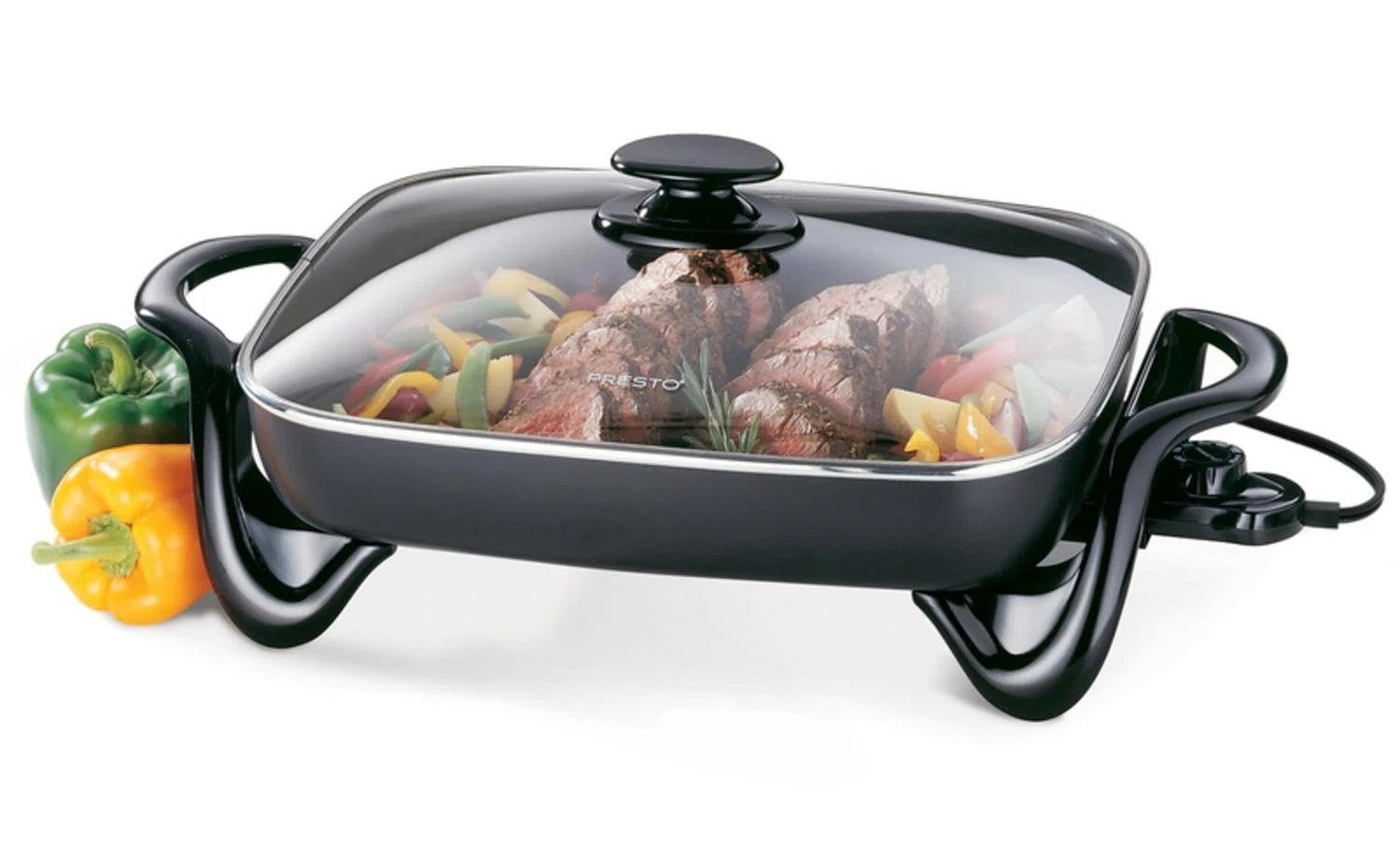 the black electric skillet with steak and peppers inside