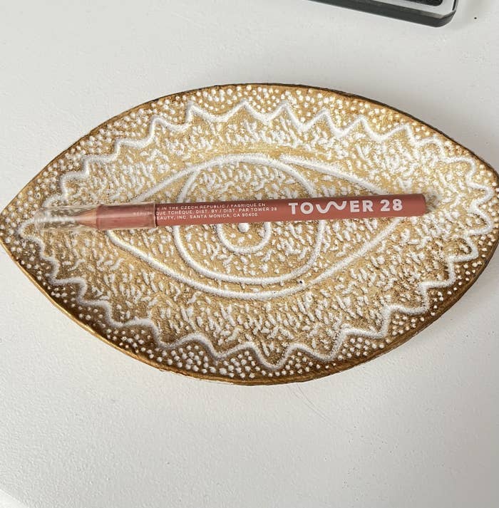 the lip liner in a trinket dish on a dresser