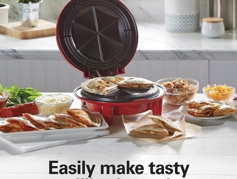 the red quesadilla maker with cooked cheese quesadilla inside
