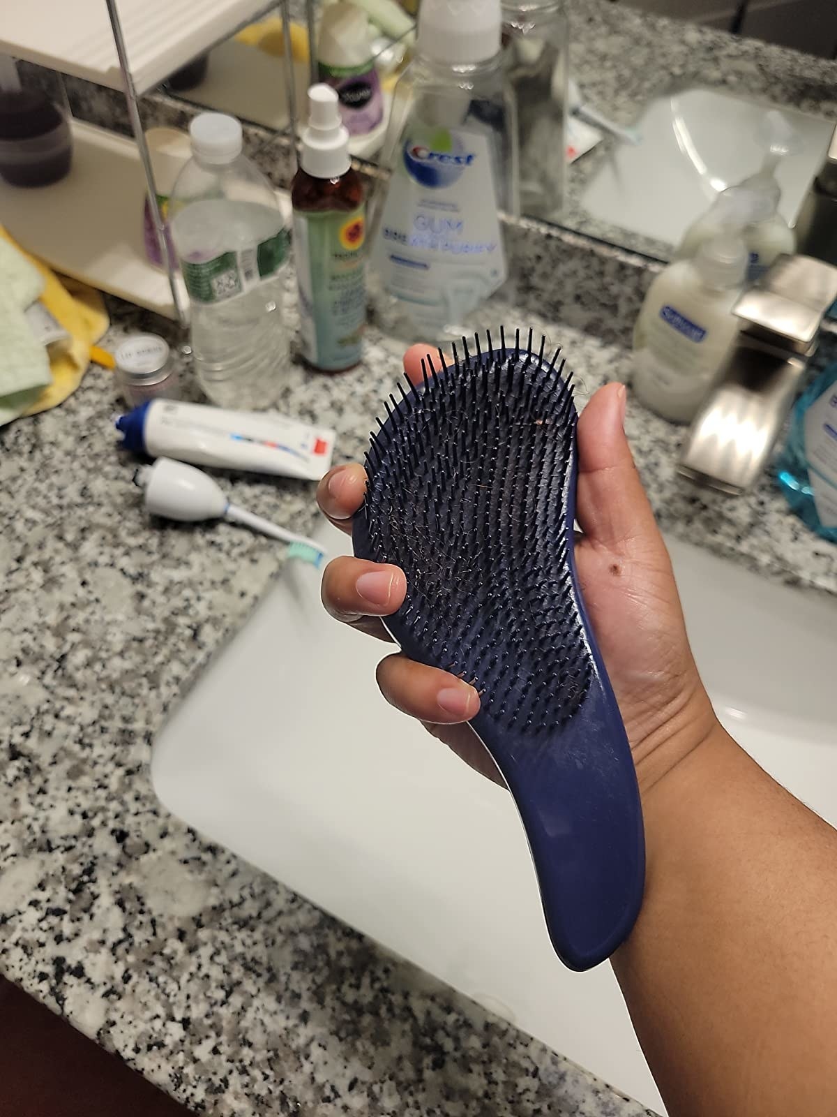 reviewer holding the brush to show off the unique shape