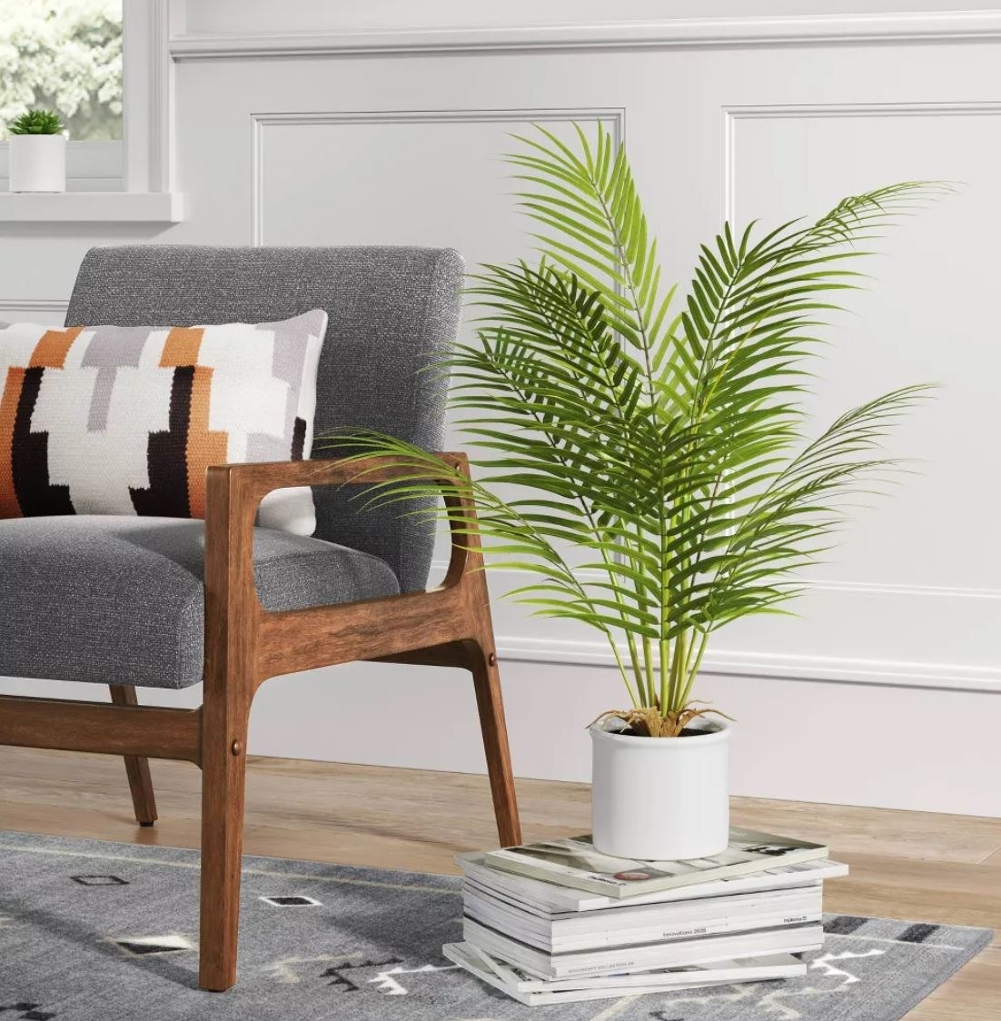 artificial palm leaves in a white ceramic pot
