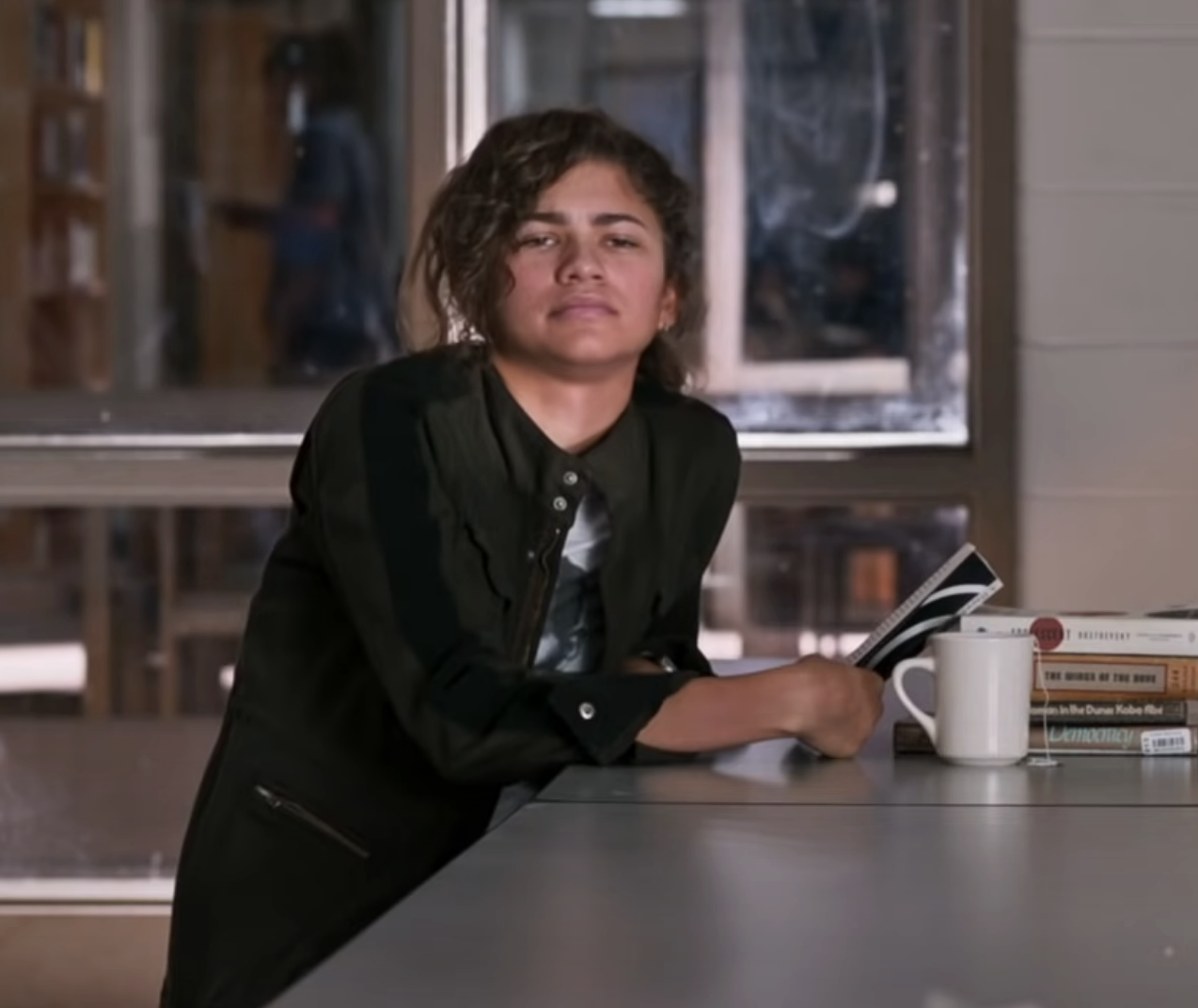 Zendaya as MJ sitting in the school cafeteria