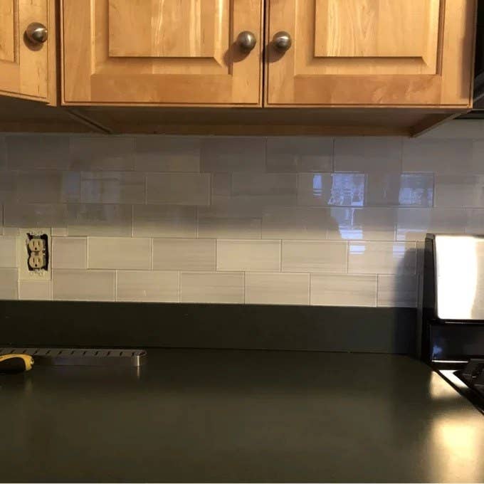 A reviewer picture of the white subway tile as a kitchen backsplash