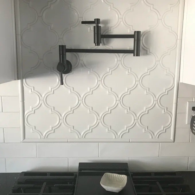 A reviewer picture of a subway tile framing a geometric-patterned backsplash