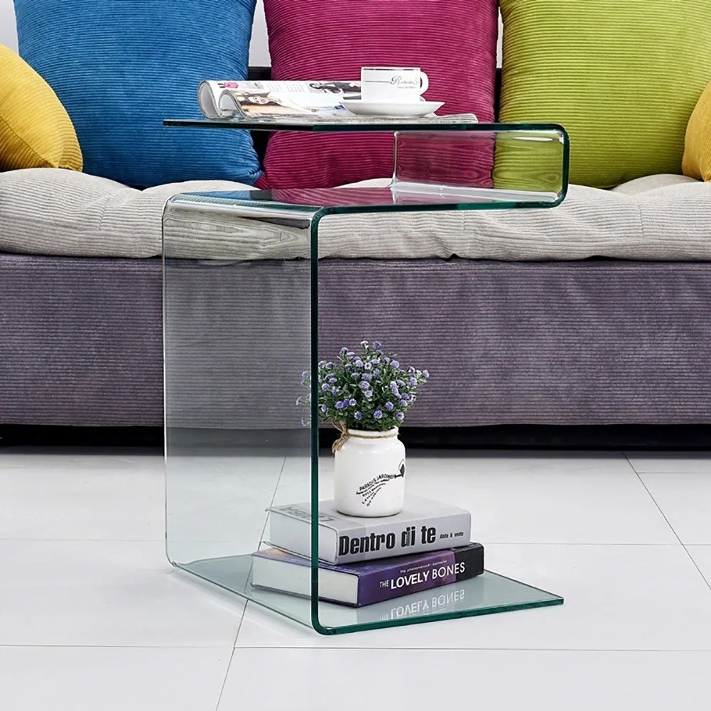 A living room style shot of the glass side table with a coffee cup and magazine on top and books below