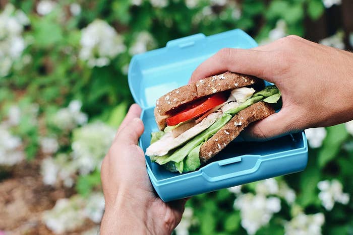 person holding the sandwich out of the box