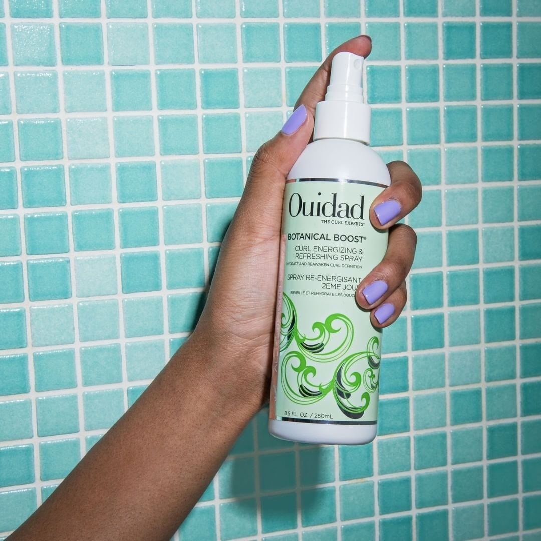 model holding the curl refreshing spray