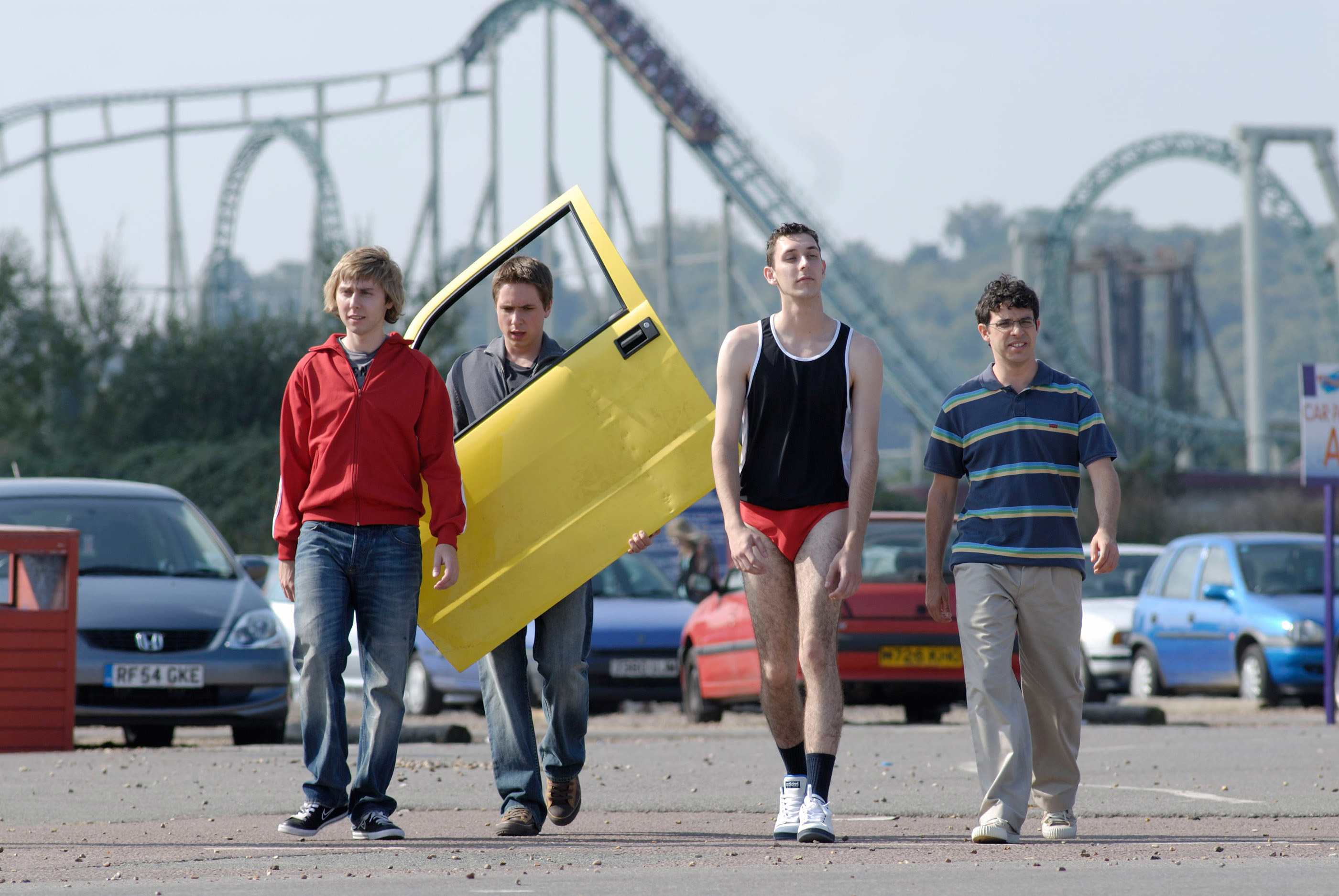 teens walking out of an amusement park holding a car door
