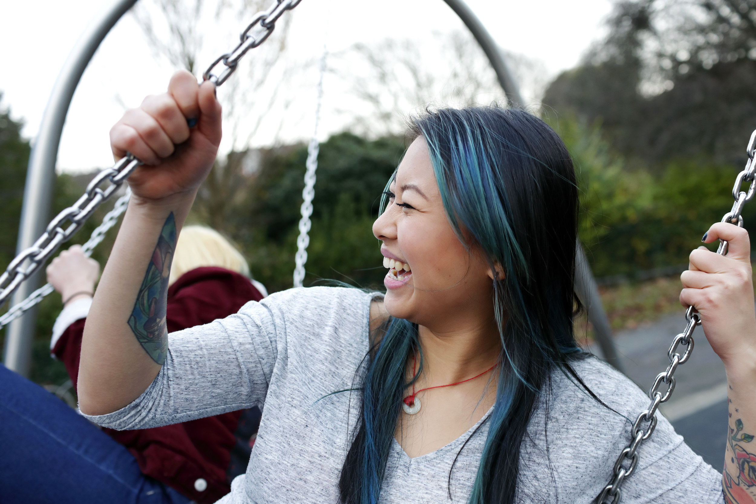 A woman with colored hair on a swing