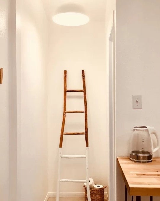 a reviewer photo of the ladder next to a basket of toilet paper
