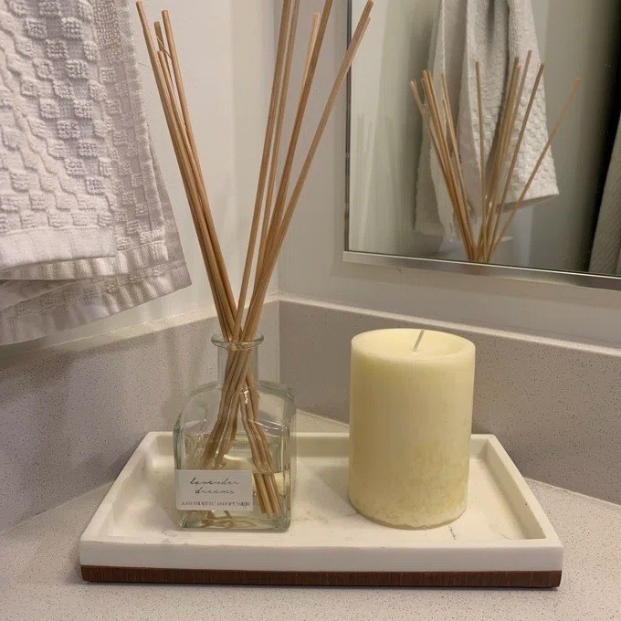 The diffuser with several reeds inside on a bathroom counter