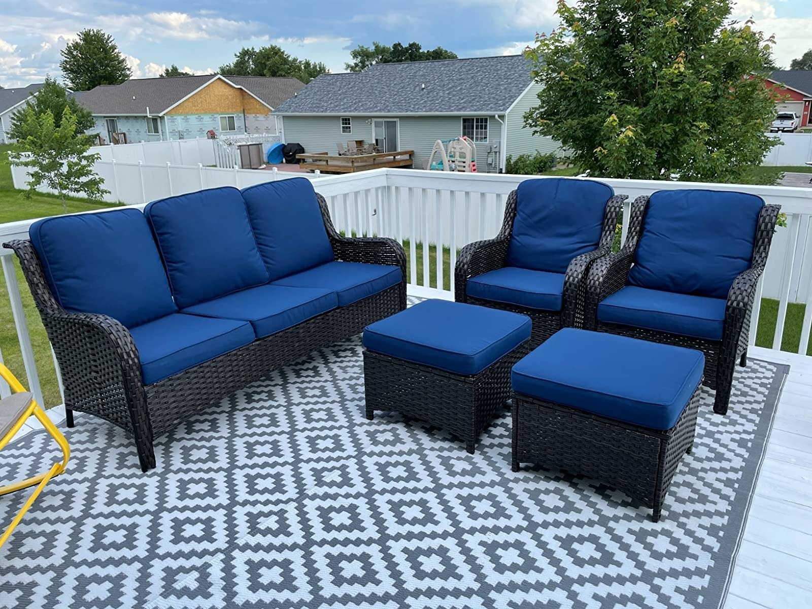 A reviewer&#x27;s phot of the five-piece patio set with blue cushions