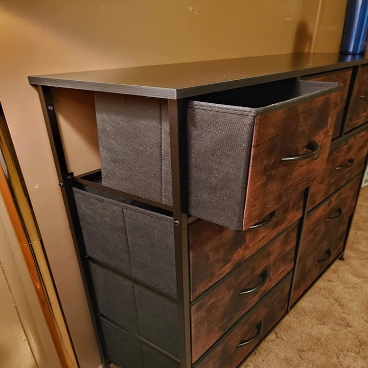 A reviewer's photo showing an open drawer of the rustic brown drawers