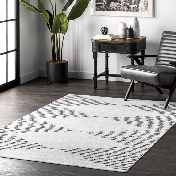white area rug with black stripes forming a repeating large triangle pattern