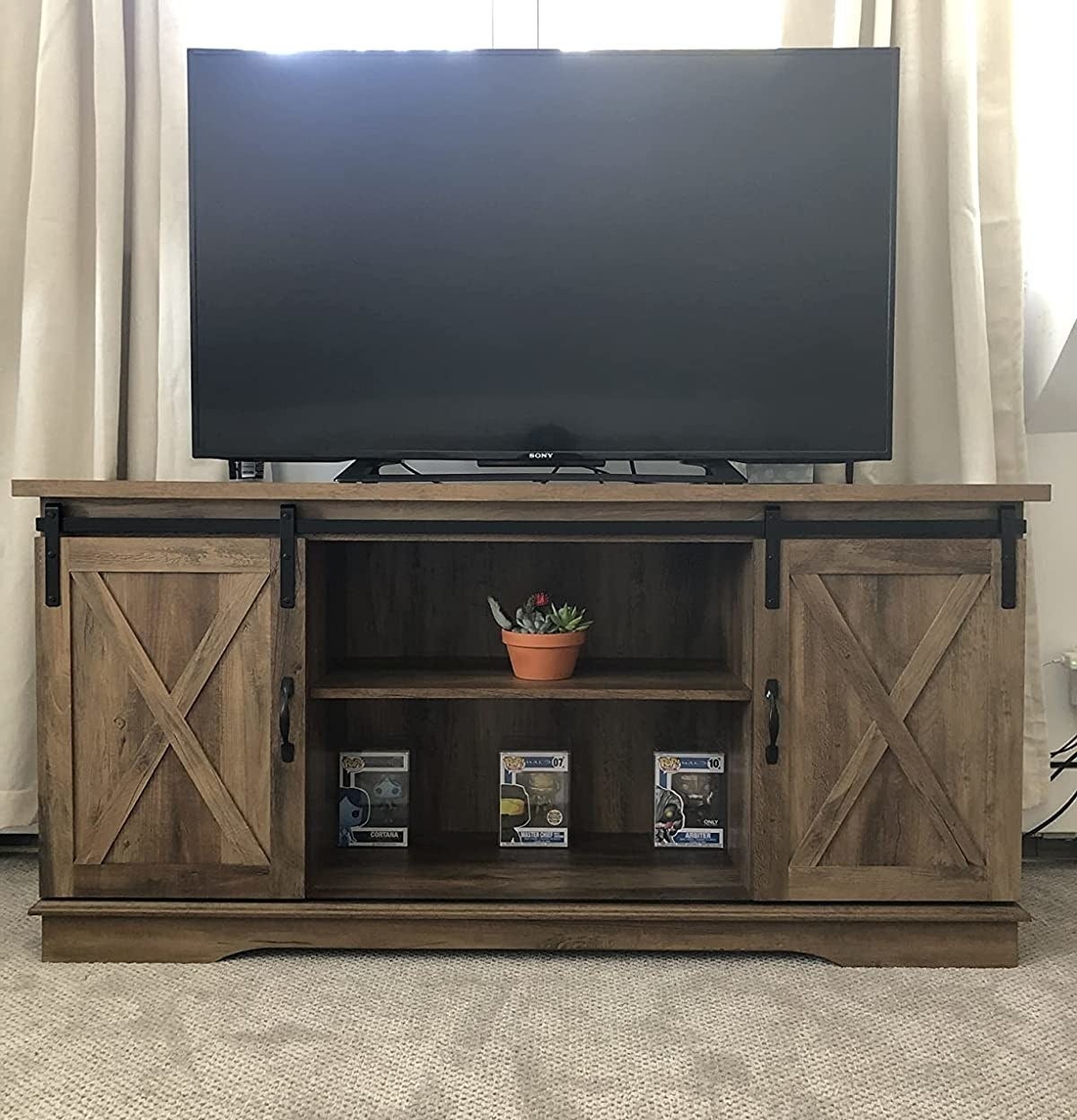 A reviewer&#x27;s photo of the TV stand with a TV on top