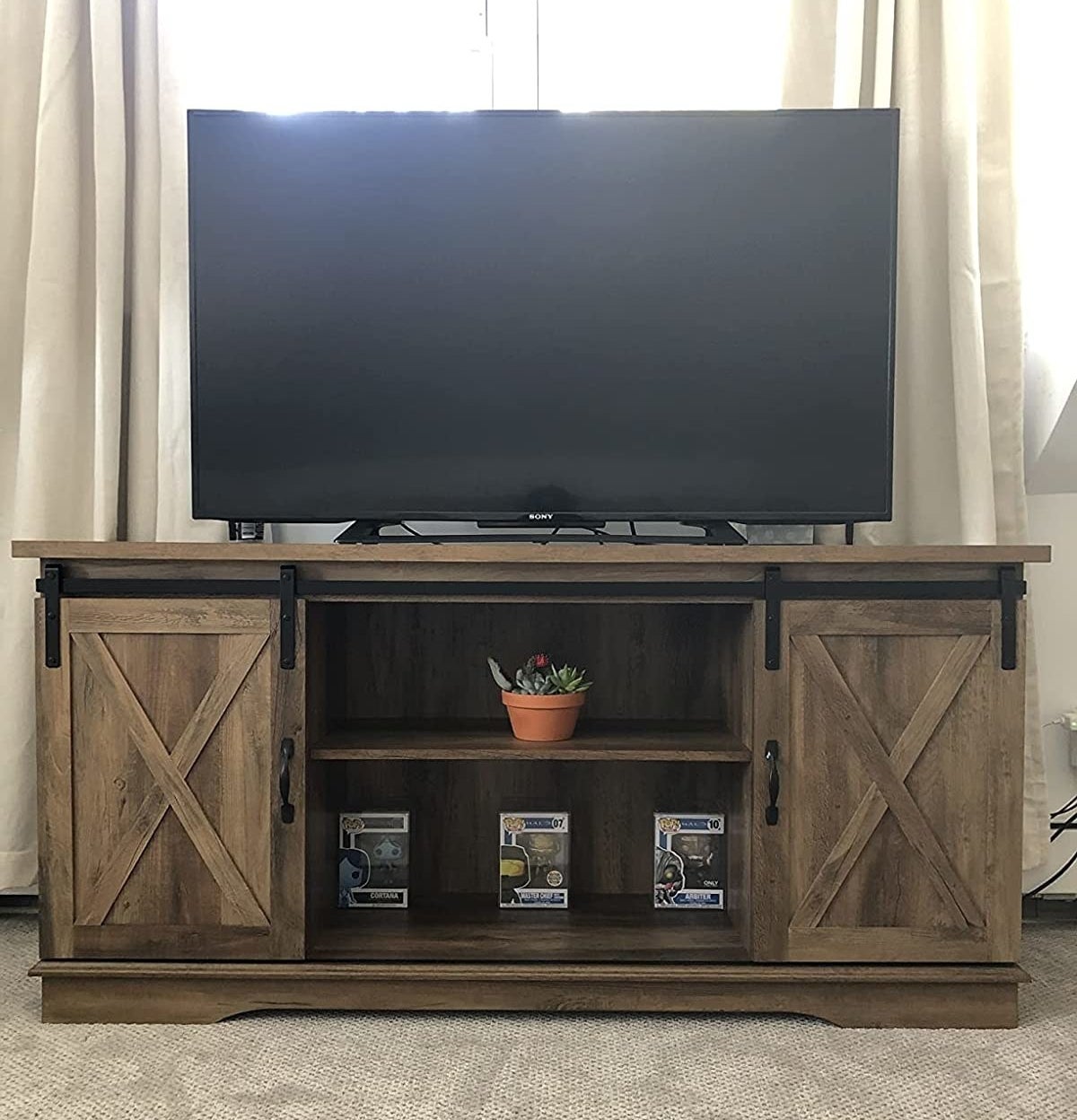 A reviewer&#x27;s photo of the TV stand with a TV on top