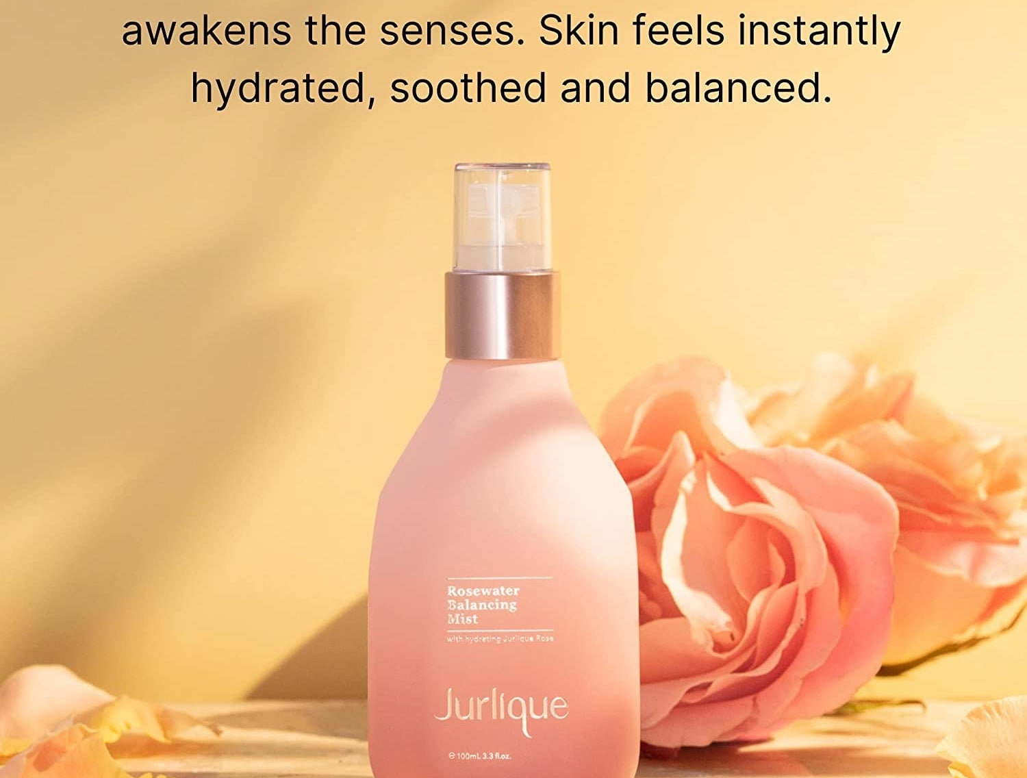 A pink bottle of skincare with pink roses
