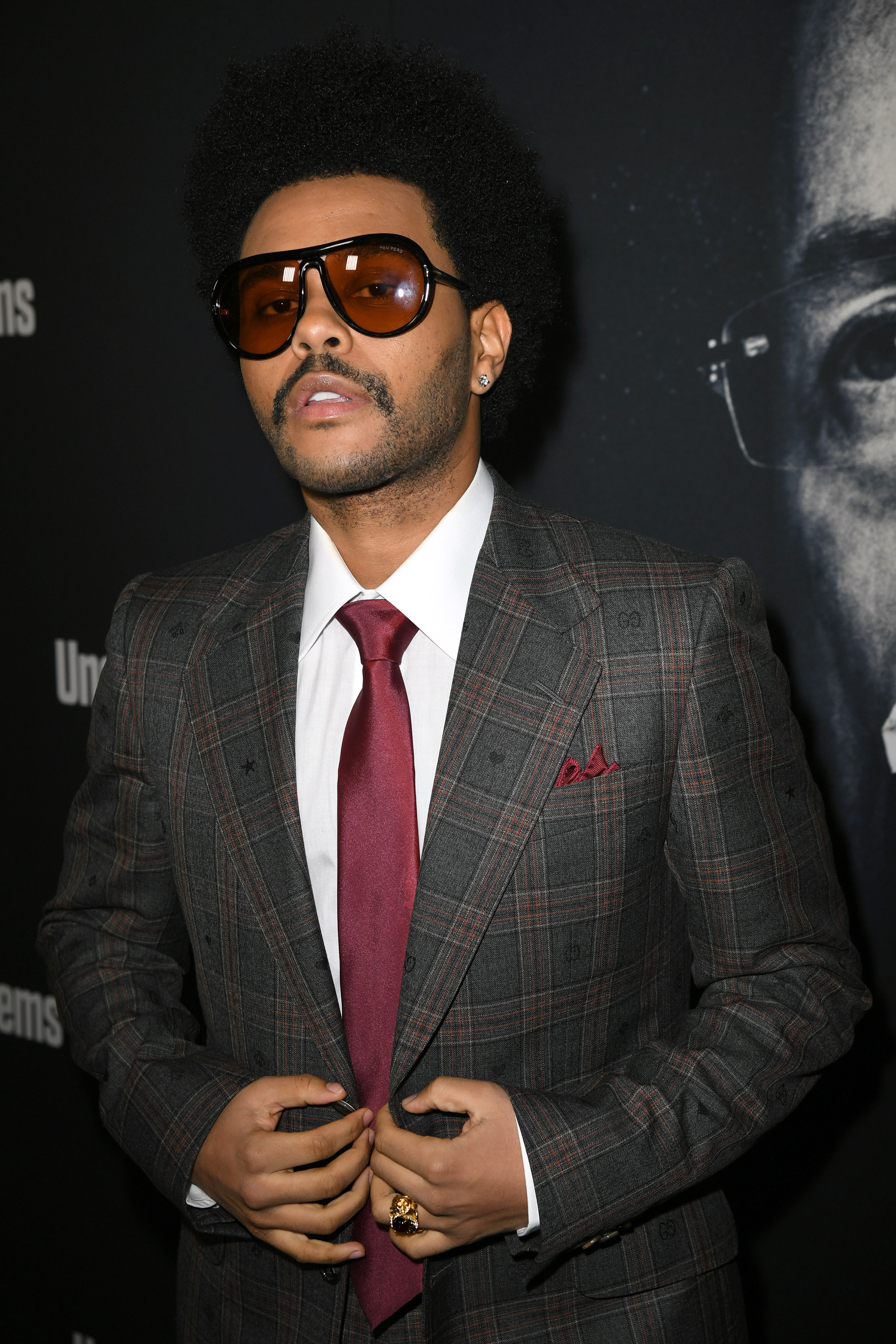 Close-up of The Weeknd in a suit and tie and sunglasses