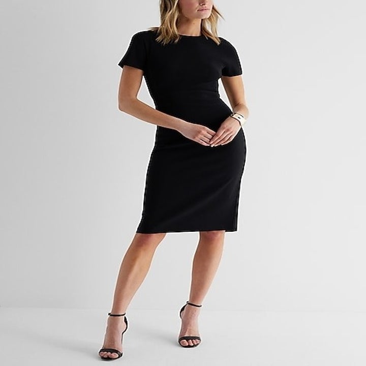 model in a knee-length black sheath dress