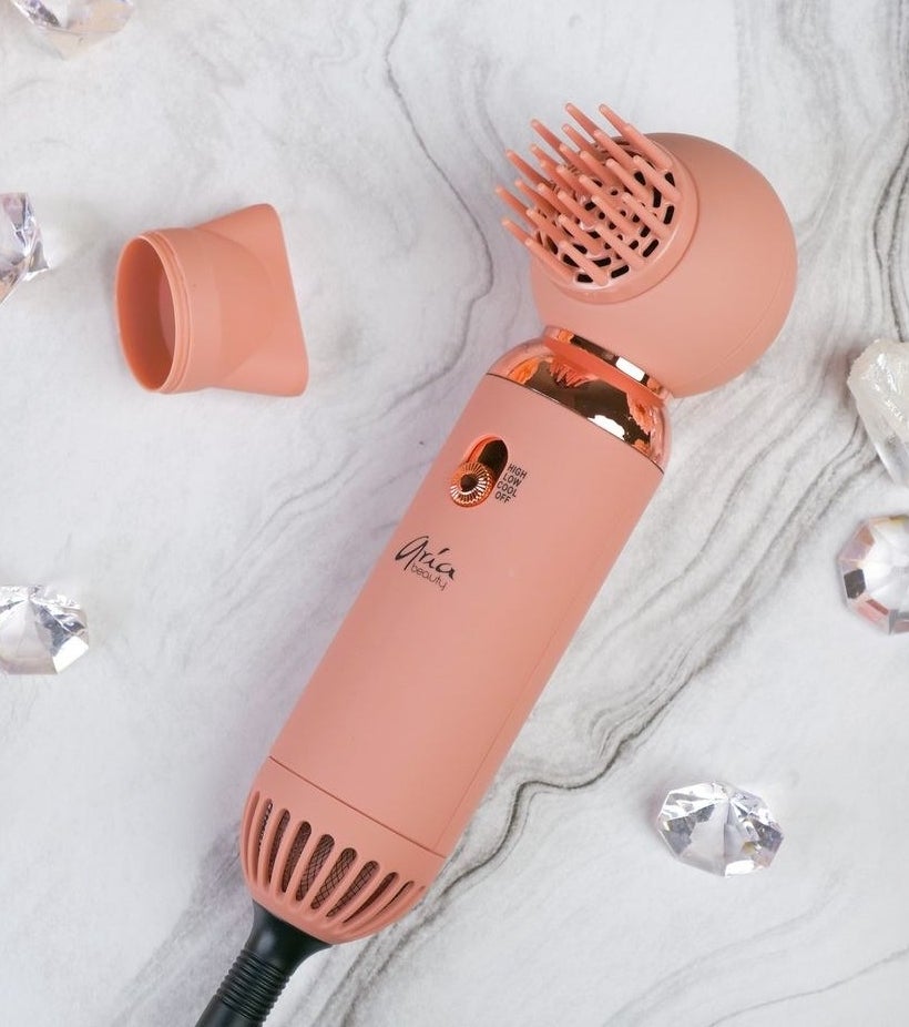 a compact hair dryer with the concentrator and diffuser attachments next to it