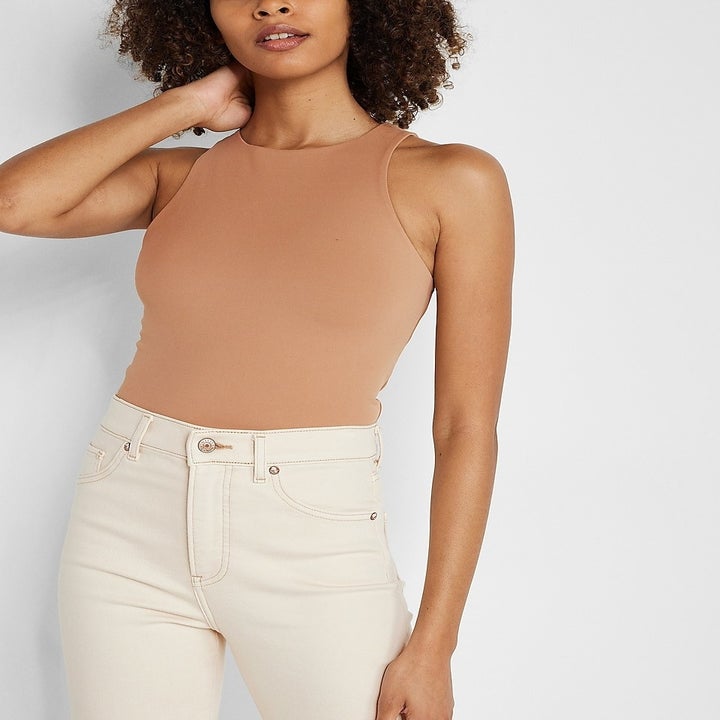 A model in the caramel colored tank with high neck