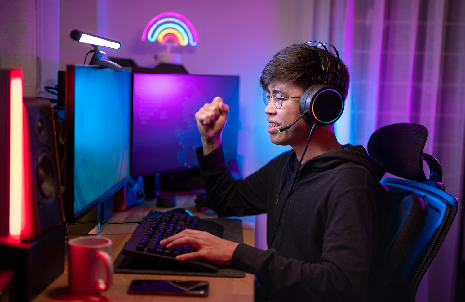 A man with a headset on in front of multiple computer screens