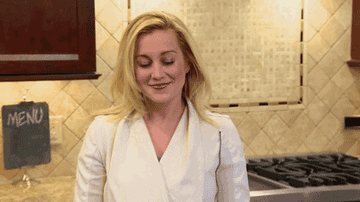 a gif of kellie pickler grooving to some chill vibes in a kitchen