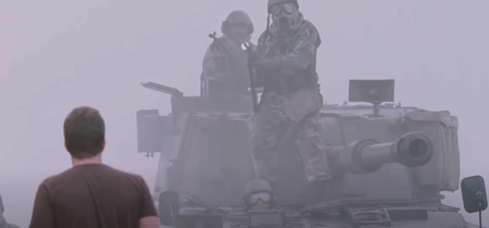 An army vehicle emerges through the mist