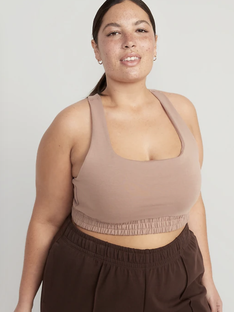 A model wearing the sports bra with pants in front of a blank background