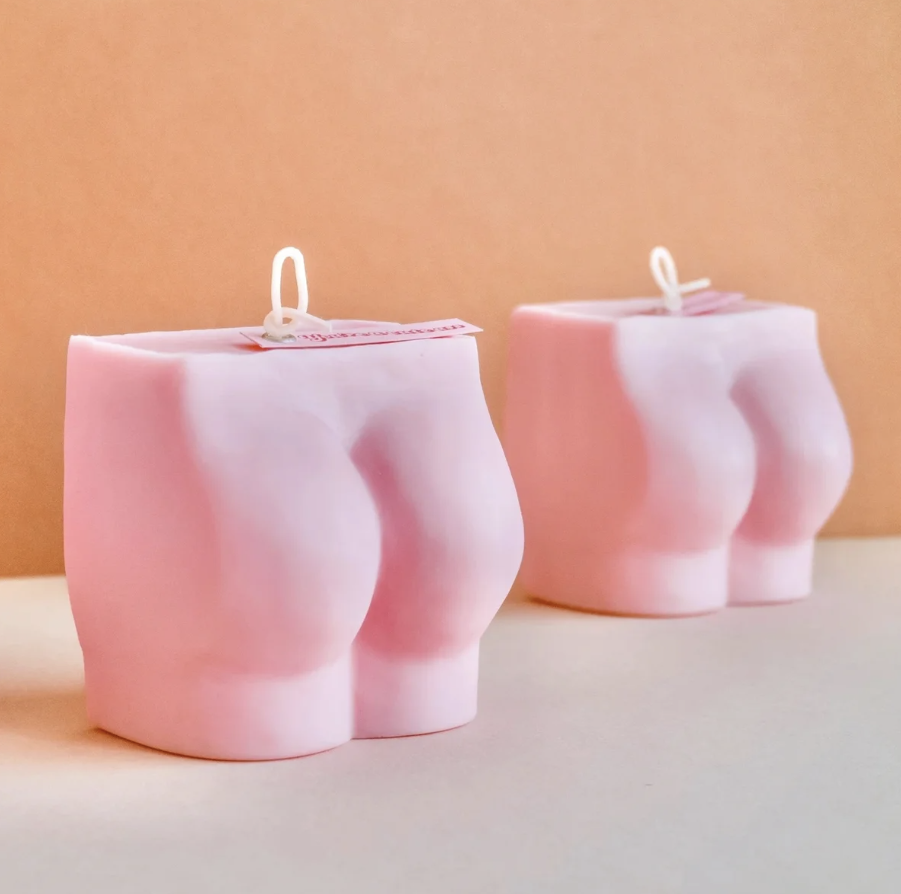 Pink booty shapes candles on orange background