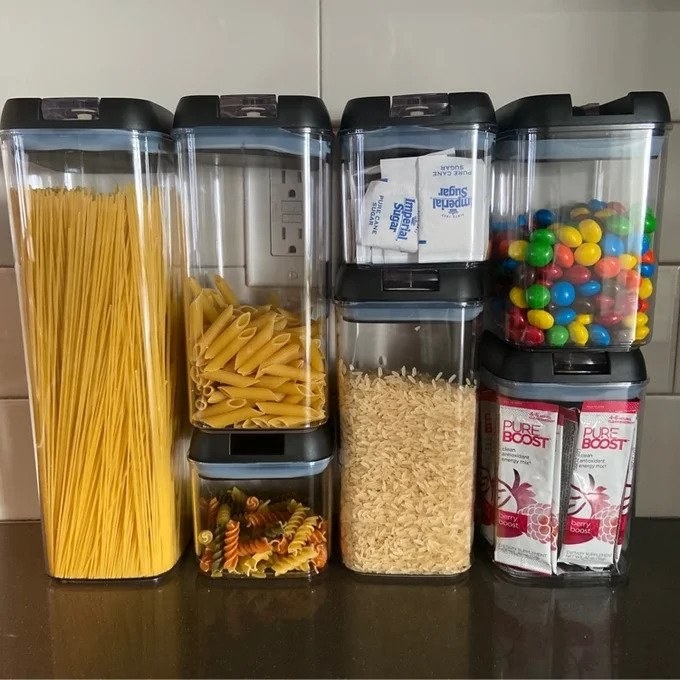 Clear storage containers with black lids, food inside
