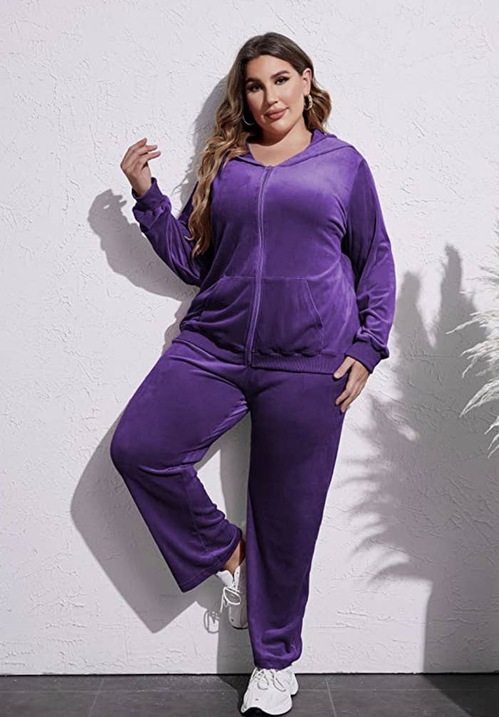 a model posing wearing the tracksuit against a plain wall