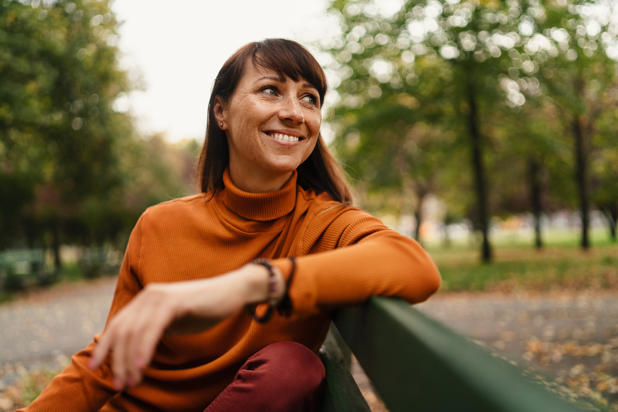 woman smiling on a bench