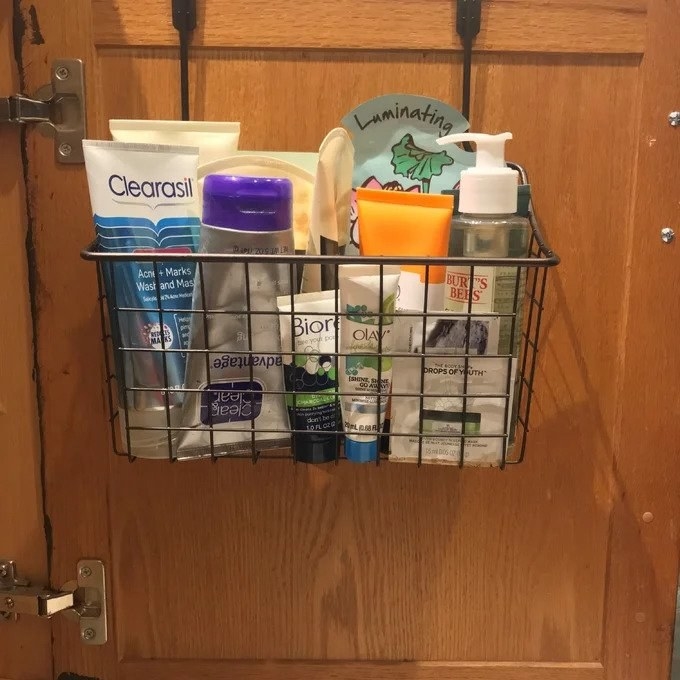 Black cabinet organizer over wooden cabinet, holding toiletries