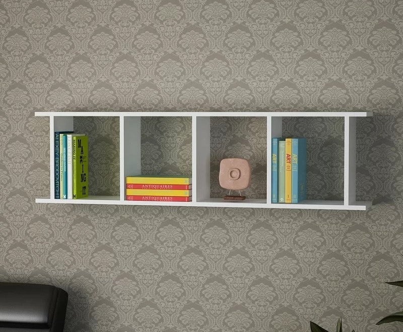 White floating book shelf with square cubbies, books and art sculpture in cubbies