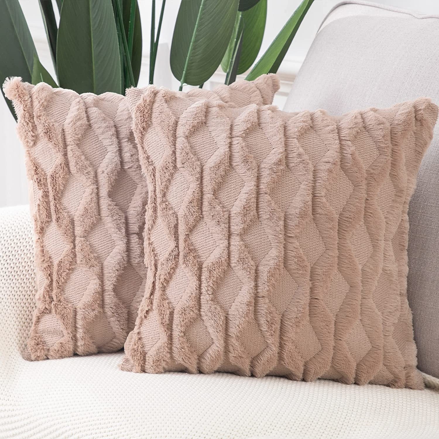 Two light pink pillows on a sofa