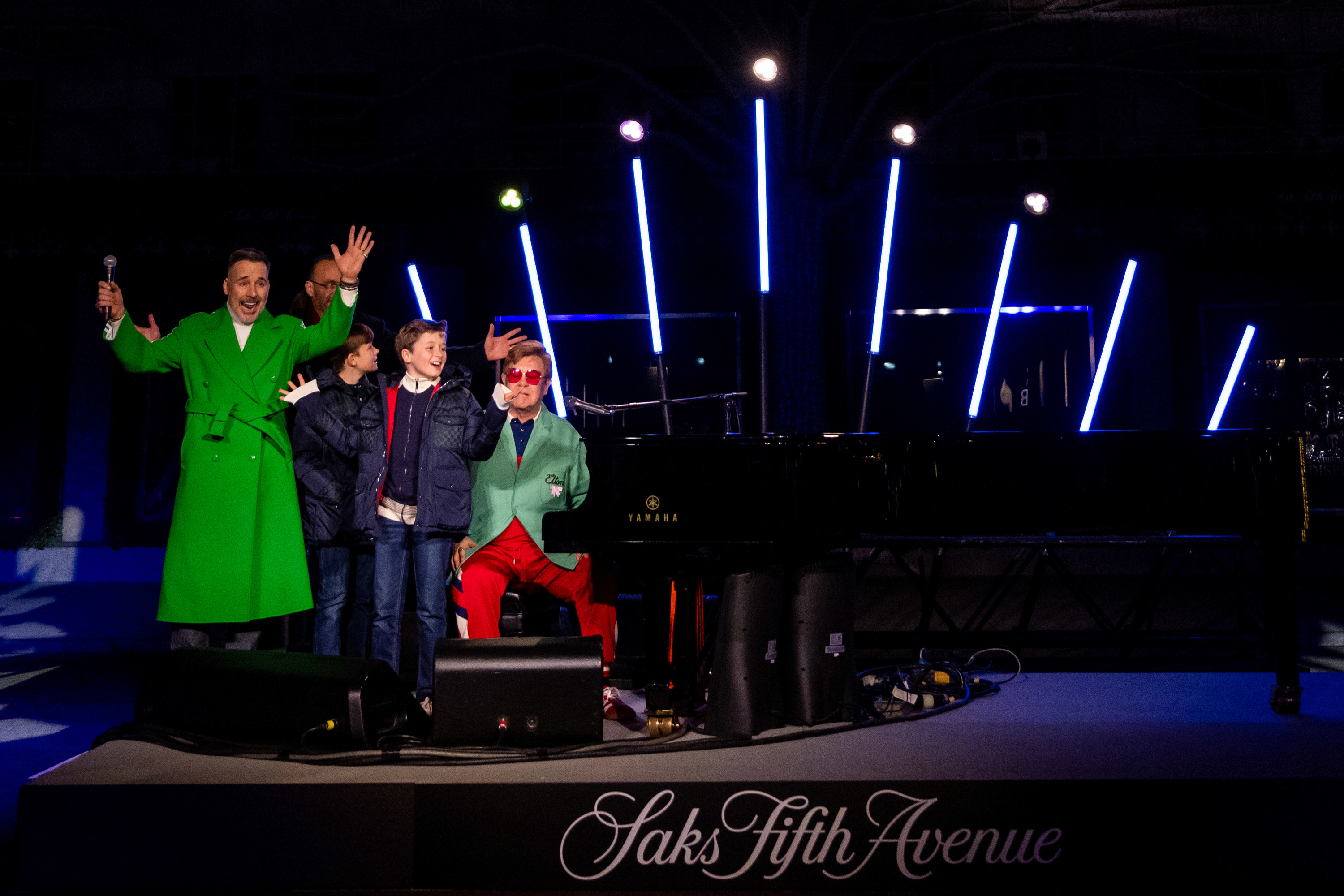 Marc J. Metrick, CEO of Saks Fifth Avenue, along with David Furnish, Elton John, and their sons — Zachary Jackson Levon and Elijah Joseph Daniel — onstage during the opening ceremony for Saks Fifth Avenue&#x27;s Holiday Windows and Light show in 2022