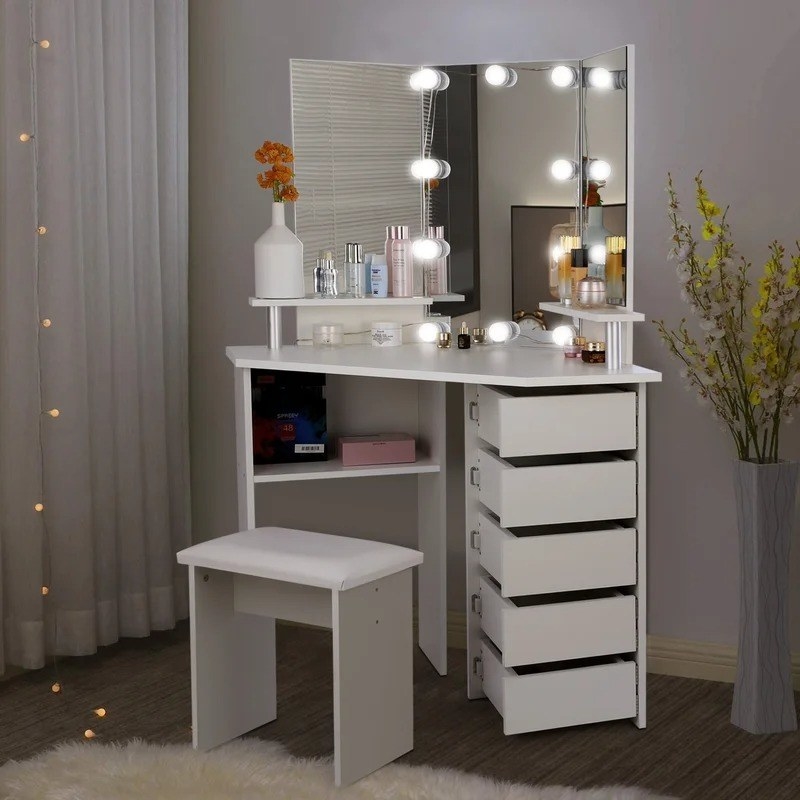 white makeup vanity with five rotatable drawers, open shelves, and mirror with lights