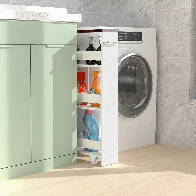 white slim utility cart with cleaning products and laundry items in between green cabinets and washing machine